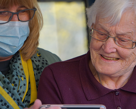 Resident with carer wearing a mask