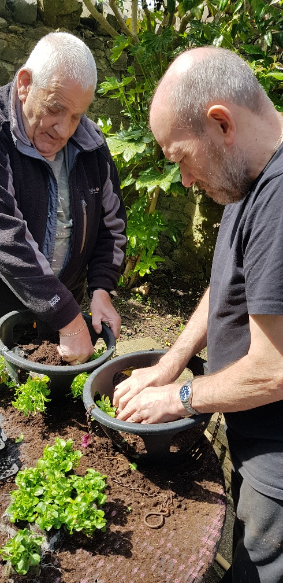 Two residents potting plants