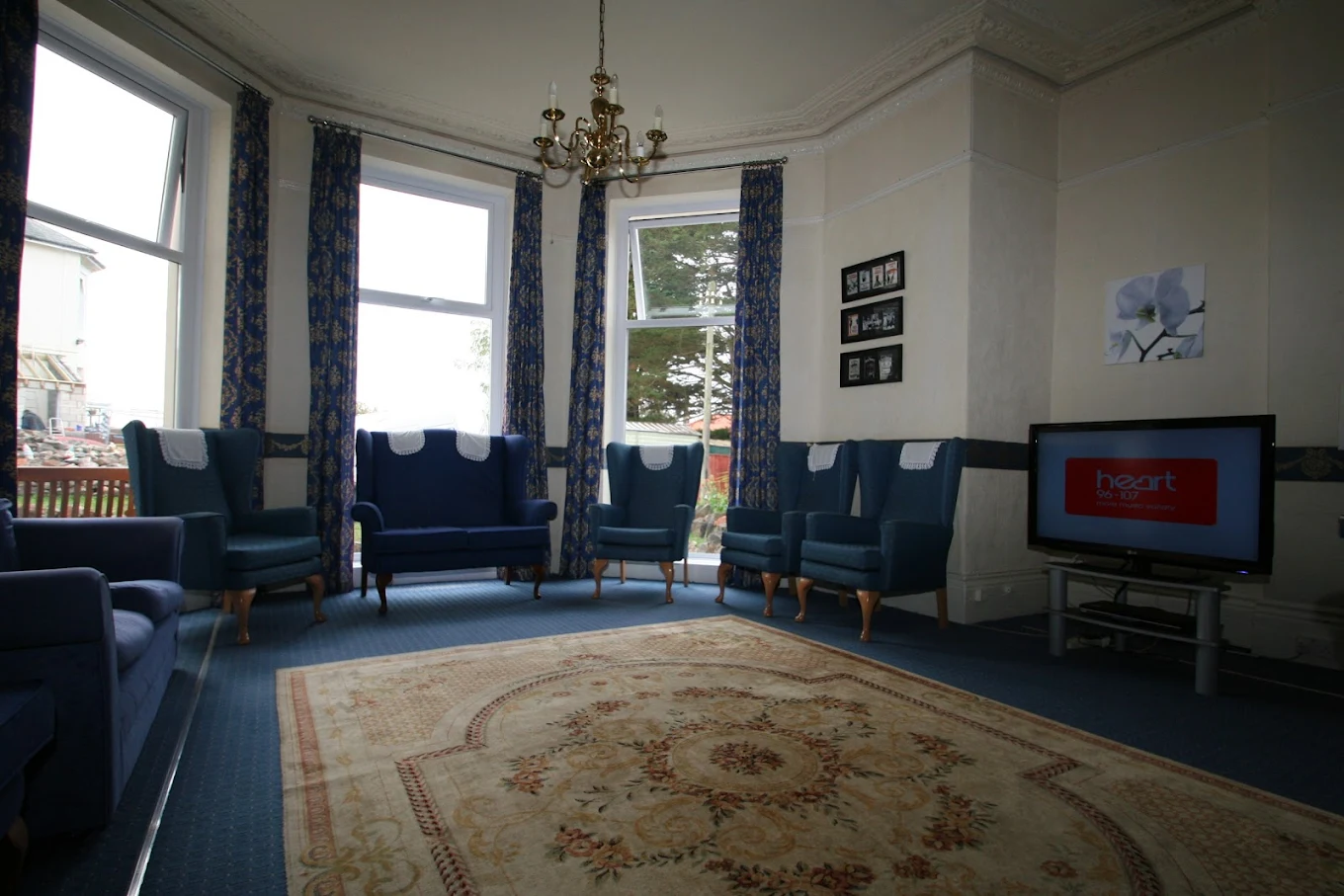 communal lounge with blue sofas and armchairs arranged in a circle